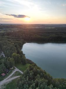 an aerial view of a lake with the sun setting at Domek Pod Jemiołami - Mały Głęboczek in Mały Głęboczek +6 photos