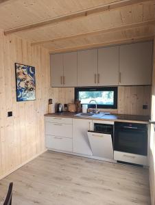 a kitchen with white cabinets and a sink and a stove at Domek Pod Jemiołami - Mały Głęboczek in Mały Głęboczek