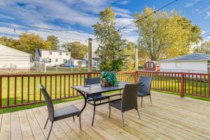 a patio with a table and chairs on a wooden deck at 2 Mi to Walden Galleria Home with Furnished Deck! in Cheektowaga
