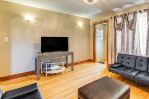 a living room with a couch and a flat screen tv at 2 Mi to Walden Galleria Home with Furnished Deck! in Cheektowaga