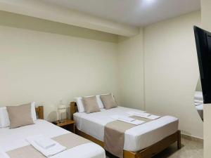 a room with two beds and a television in it at studio confort in Iquitos +4 photos