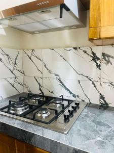 a stove top in a kitchen with a marble wall at studio confort in Iquitos