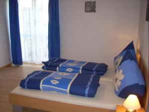 a bed with blue and white sheets on it at Gemütliche Ferienwohnung nähe Wutachschlucht in Hüfingen