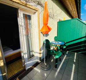 un parasol orange et une table et des chaises sur un balcon dans l'établissement Pension am Campus Velden, à Velden am Wörther See 20 autres photos