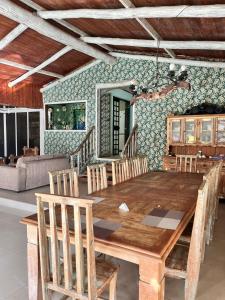 a dining room with a wooden table and chairs at Ótima casa próxima a praia e o centro in Ilhabela