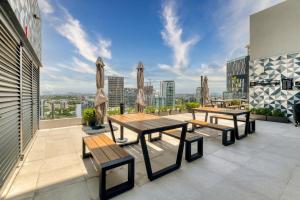 a patio with tables and benches on top of a building at Nido x Nomad Pablo Neruda GDL in Guadalajara