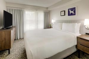 a hotel room with a large bed and a flat screen tv at Sonesta ES Suites Anaheim Resort Area in Anaheim