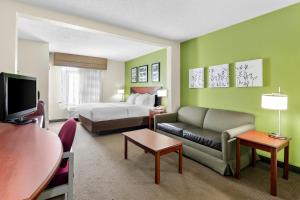 a hotel room with a bed and a couch at Sleep Inn & Suites Princeton I-77 in Princeton