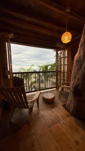 a room with a chair and a view of the ocean at El Almendrón Beach Hostel in Santa Marta +54 photos