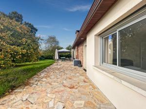 a stone walkway next to a house with a window at Confort et Bien-être in Désertines