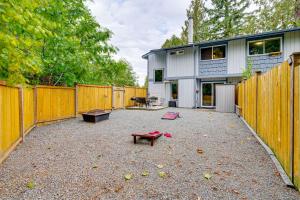 une arrière-cour avec une clôture en bois et une maison dans l'établissement Walk to Lake Stevens Duplex with Fire Pit!, à Lake Stevens