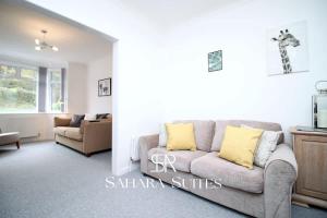 ein Wohnzimmer mit einem grauen Sofa und gelben Kissen in der Unterkunft 3BR Retreat Near Tredegar & Newport Hub in Rogerstone + 18 Fotos