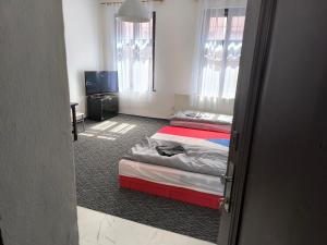 a hotel room with two beds and a television at Apartmán Hanka in Pardubice