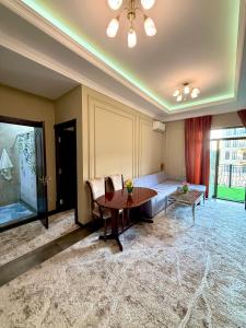 ein Wohnzimmer mit Tisch und Couch in der Unterkunft Tashkent city Boulevard resident 04 in Taschkent