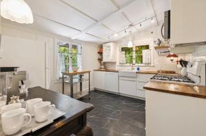 a kitchen with white cabinets and a counter top at Adobe Cottage at Speakeasy Hotel - Adults Only in Palm Springs