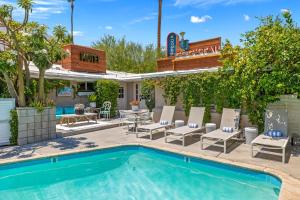 a pool with chairs and a table and a house at Adobe Cottage at Speakeasy Hotel - Adults Only in Palm Springs
