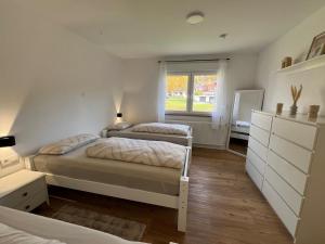 een slaapkamer met twee bedden en een raam bij Traumhafte 3 Zimmer Ferienwohnung mit Balkon in Freudenberg am Main