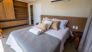 een slaapkamer met een bed met handdoeken erop bij Casa de luxo pé na areia na Praia Marceneiro em Milagres in São Miguel dos Milagres +36 foto's