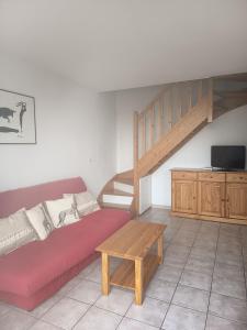 カルヴィッソンにあるMaison le Mimosaのリビングルーム(赤いソファ、木製テーブル付) +1枚の写真