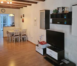 a living room with a television and a table with chairs at Gemütliche Ferienwohnung nähe Wutachschlucht in Hüfingen