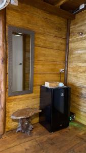 a room with a wooden wall with a bench and a mirror at El Almendrón Beach Hostel in Santa Marta