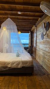 a bedroom with a bed with a mosquito net at El Almendrón Beach Hostel in Santa Marta
