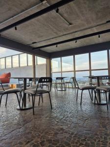 un grupo de mesas y sillas en una habitación con ventanas en STÚDIO - Novo e Sofisticado!, en Princesa dʼOeste 27 fotos más