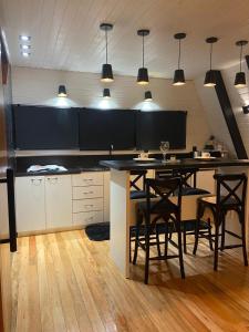 een keuken met een tafel, stoelen en verlichting bij Cabana Álamo-Guimarães Reserva in Cambará