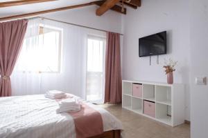 een slaapkamer met een bed en een tv aan de muur bij Ammon Chalet in Bran +86 foto's