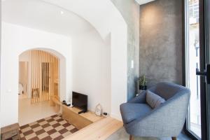 uma sala de estar com uma cadeira azul e uma televisão em FLH Modern Flat Principe Real em Lisboa