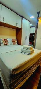 a large bed in a room with white cabinets at Um Compacto Perfeito no Batel in Curitiba