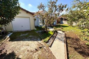 a backyard of a house with a garage at Bright house with garden in Saint-Sébastien-sur-Loire