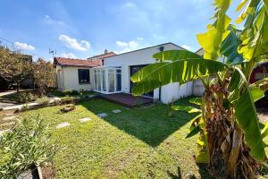 a backyard of a white house with a yard at Bright house with garden in Saint-Sébastien-sur-Loire