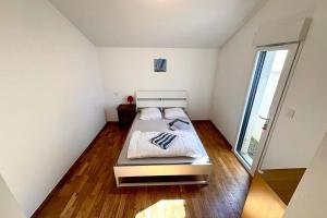 a small bedroom with a bed and a large window at Bright house with garden in Saint-Sébastien-sur-Loire