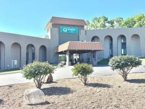 a building with three trees in front of it at Quality Inn in West Des Moines