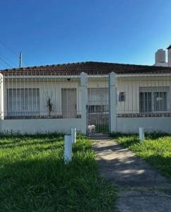 a house with a dog sitting in front of it at Chalet House in La Plata  +12 photos