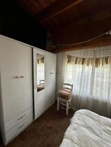 a bedroom with a bed and a window and a chair at Chalet House in La Plata in La Plata