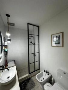 a white bathroom with a toilet and a sink at Chalet House in La Plata 
