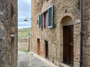 an alley in a stone building with doors and windows at Casina Gattoli in Montalcino