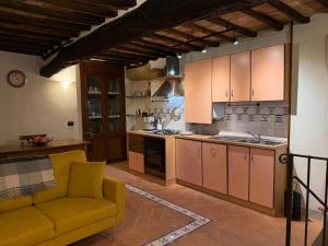 a kitchen with a yellow couch in a room at Casina Gattoli in Montalcino +14 photos