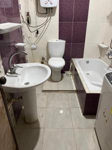 a bathroom with a toilet and a sink and a tub at A dublex villa in Ghaţāţī