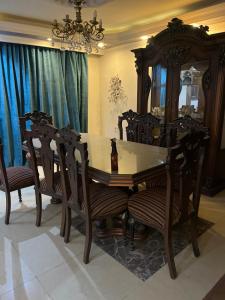 a dining room with a wooden table and chairs at A dublex villa in Ghaţāţī