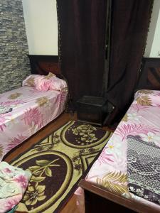 a room with two beds and a rug at A dublex villa in Ghaţāţī