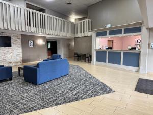 a lobby with two blue chairs and a rug at Quality Inn in West Des Moines