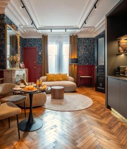 een woonkamer met een bank en een tafel bij Villa Emilia - Suites de prestige au coeur de Nancy in Nancy