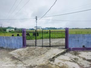 an iron gate with a view of a field at Adoreen Homestay in Cherrapunji