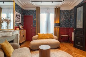 een woonkamer met een bank en een open haard bij Villa Emilia - Suites de prestige au coeur de Nancy in Nancy +32 foto's