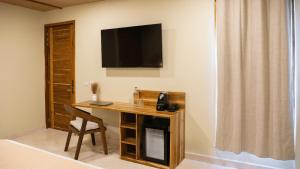 een kamer met een bureau en een televisie aan de muur bij Luuna de Jade in Oaxaca City