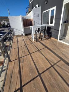 a deck with a table and chairs on a house at Sol del Atardecer in Rada Tilly