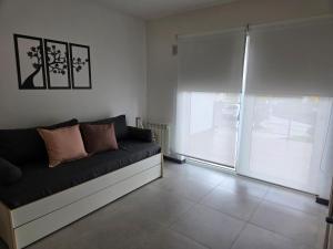 a living room with a couch and a sliding glass door at Sol del Atardecer in Rada Tilly +2 photos